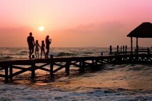 couple with two young kids on a boardwalk during a sunset
